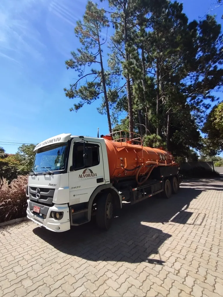 Caminhão pipa estacionado sob árvores