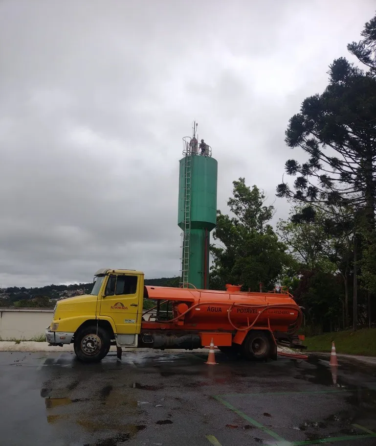 Caminhão pipa de água potável junto a caixa d'água